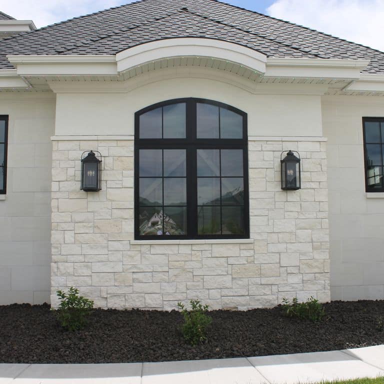 Feature image for Blanco Limestone. The image shows this material being used for full bed veneer and thin veneer. Dominant colors shown are gray and white; with beige and cream secondaries. The color mix creates a cool feeling. Solid, regular and cloudy color patterns.