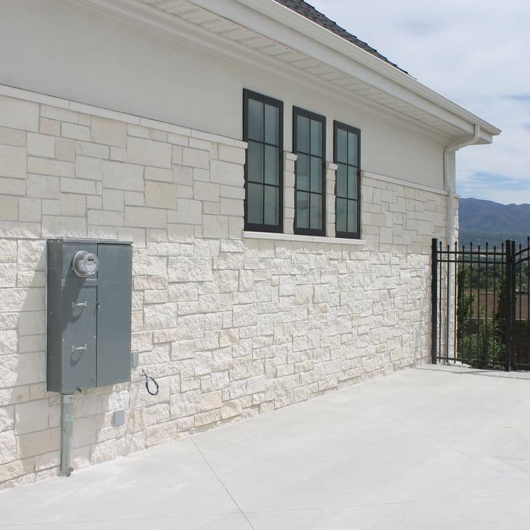 Application image for Blanco Limestone. The image shows this material being used for full bed veneer and thin veneer. The surface finish shown is split-face. The dominant color shown is white; with a cream secondary. The color mix creates a warm feeling. Solid color pattern.