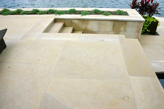 Application image for Regent Buff Limestone. The image shows this material being used for patio pavers and treads. Dominant colors shown are beige and tan; with gray and cream secondaries. The color mix creates a warm feeling. Blotched color pattern.