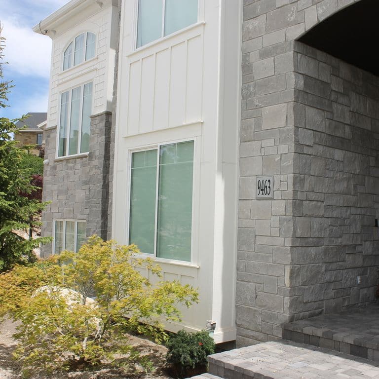 Application image for Platinum Limestone. The image shows this material being used for landings, full bed veneer and thin veneer. The surface finish shown is split-face with rough plane. The dominant color shown is gray; with a purple secondary. The color mix creates a cool feeling. Solid color pattern.
