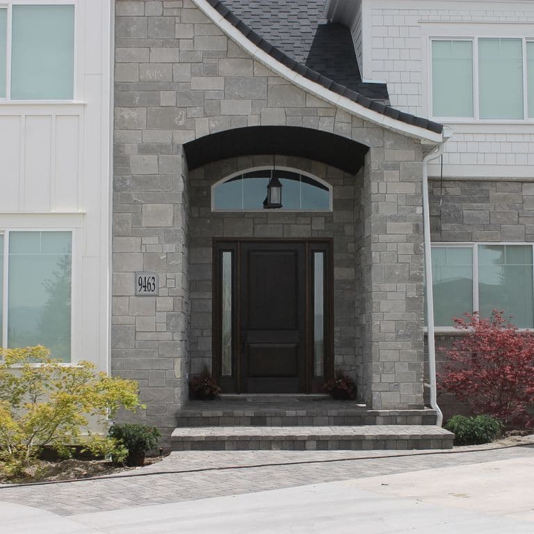 Application image for Platinum Limestone. The image shows this material being used for full bed veneer and thin veneer. The surface finish shown is split-face. The dominant color shown is gray; with a white secondary. The color mix creates a cool feeling. Regular color pattern.