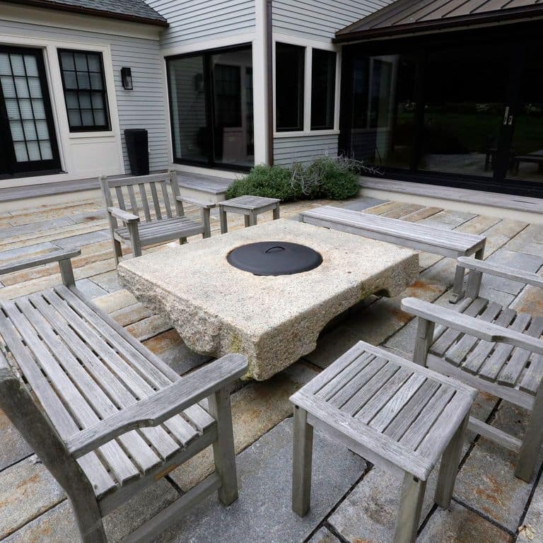 Feature image for Reclaimed Historic Streetscape Stones. The image shows this material being used for outdoor fire concepts and patio pavers. Dominant colors shown are gray and cream; with beige, blue, brown, white and tan secondaries. Random, speckled and blotched color patterns.