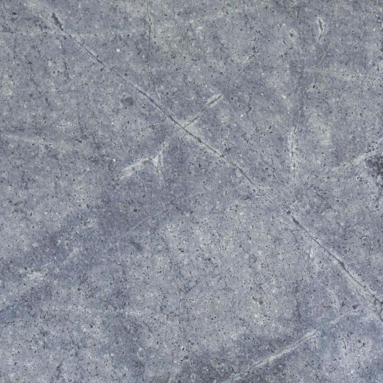 Close-up image for Atlantic Granite. The surface finish shown is honed. Dominant colors shown are blue and gray. Exhibits "movement" and the color mix creates a cool feeling. Fine speckled, blotched and veined color patterns. Contains mineral inclusions.
