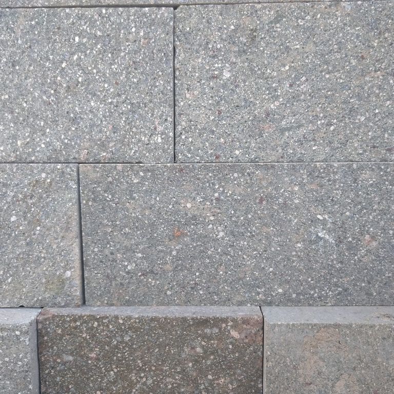 Close-up image for Porphyry Natural Surface - Gray Selected. The surface finishes shown are natural cleft and split-face. The dominant color shown is gray; with purple and white secondaries. The color mix creates a cool feeling. Speckled and fine speckled color patterns.