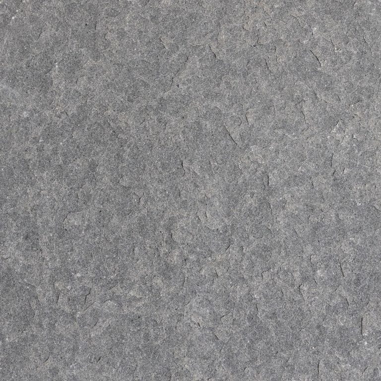 Close-up image for Polar Gray Limestone. The surface finish shown is flamed. The dominant color shown is gray; with a purple secondary. The color mix creates a cool feeling. Regular and cloudy color patterns.