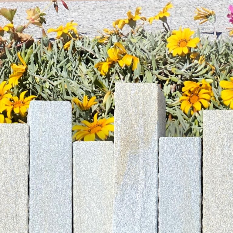 Application image for Pietra Italia Gneiss. The image shows this material being used in a landscape curbing &amp; edging application. Dominant colors shown are gray and tan. The color mix creates a warm feeling.