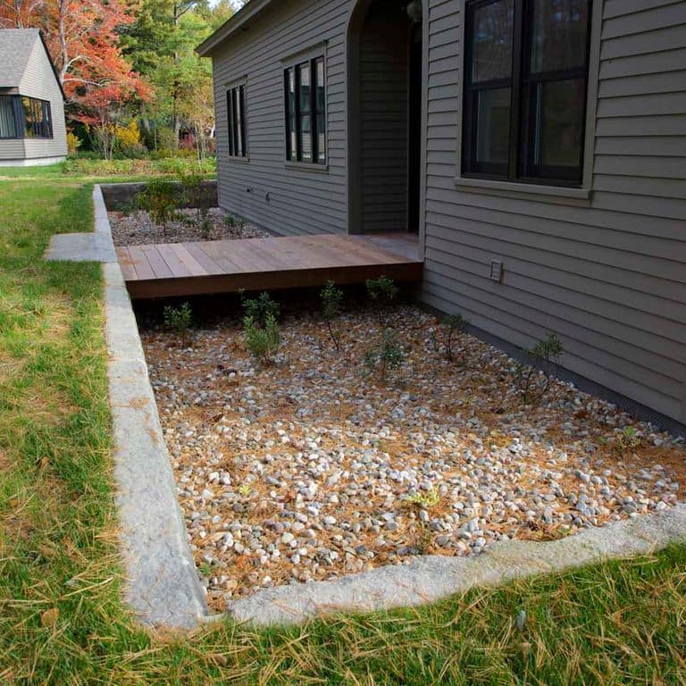Application image for Reclaimed First Generation Granite Curbstone. The image shows this material being used in a landscape curbing &amp; edging application. This is a building and landscape stone for indoor and outdoor commercial and residential applications. Suitable for general use, freeze-thaw conditions, low heat absorption surfaces, high traffic areas, low slipperiness surfaces and high heel compatibilty situations. Moderate to higher on the price spectrum.