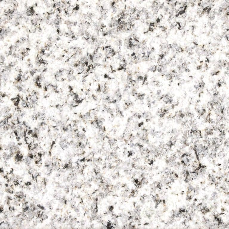Color/Finish variation image for Crystal White Granite. The surface finish shown is sand blasted. Dominant colors shown are gray, white and cream; with a beige secondary. The color mix creates a warm feeling. Coarse speckled color pattern.