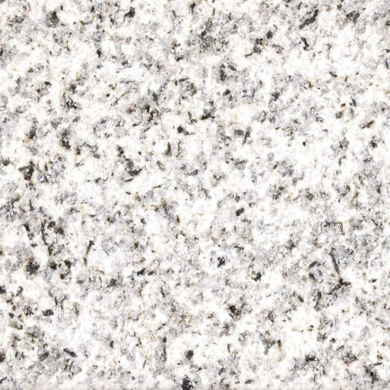 Close-up image for Crystal White Granite. The surface finish shown is sand blasted. Dominant colors shown are gray, white and cream; with beige and pink secondaries. Coarse speckled color pattern. Contains some mica and mineral inclusions.