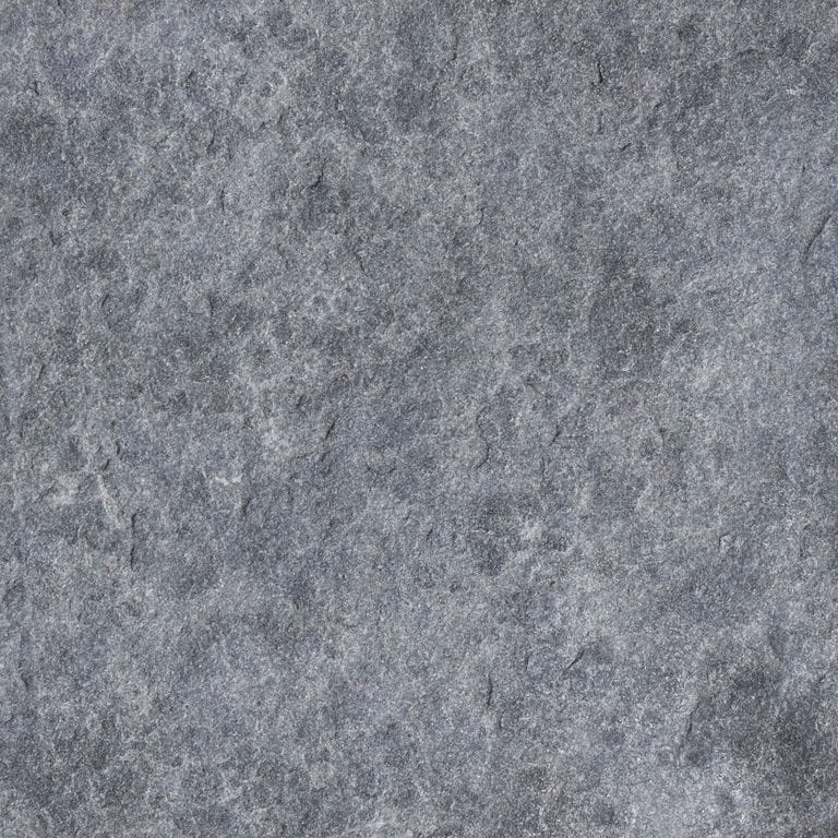 Close-up image for Vietnam Black Basalt. The surface finish shown is flamed. The dominant color shown is gray; with a purple secondary. The color mix creates a cool feeling. Regular color pattern.