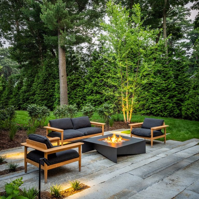 Feature image for Granite - Reclaimed Third Generation Curbstone. The image shows this material being used in a patio pavers application. The dominant color shown is gray. The color mix creates a warm feeling.