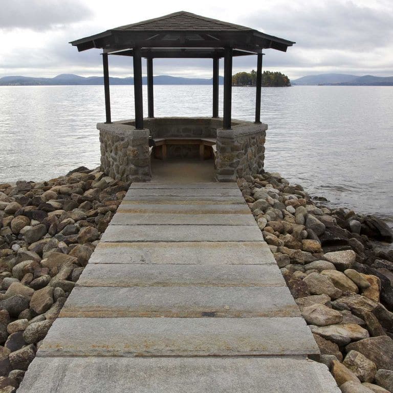 The image shows this material being used for path pavers and patio pavers. The dominant color shown is gray; with brown and orange/rust secondaries. Regular color pattern.