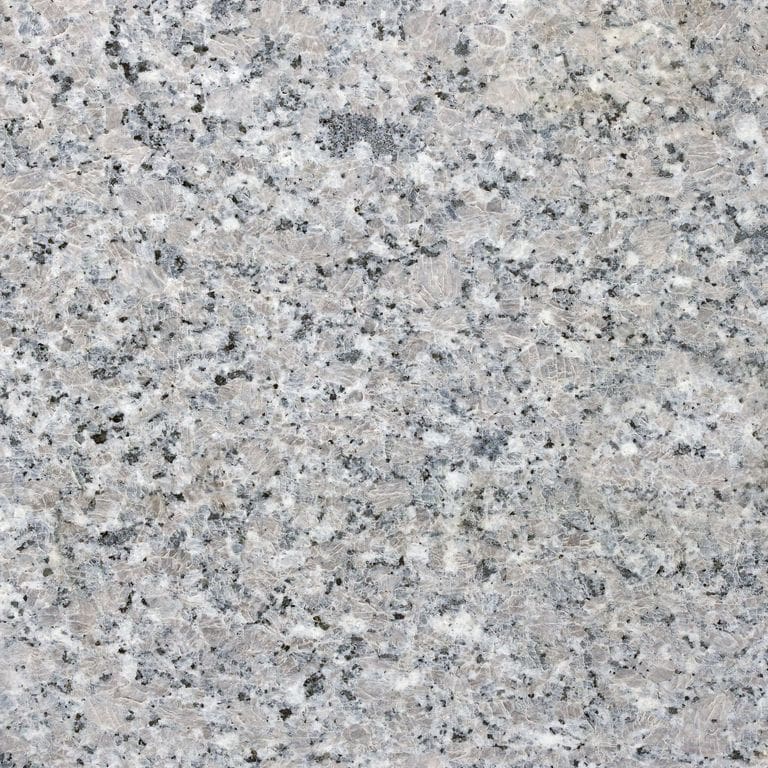 Best close-up image for Kershaw Pink Granite. The surface finish shown is honed. Dominant colors shown are beige, gray and white; with purple and cream secondaries. The color mix creates a cool feeling. Coarse speckled color pattern. Contains some mica and mineral inclusions.