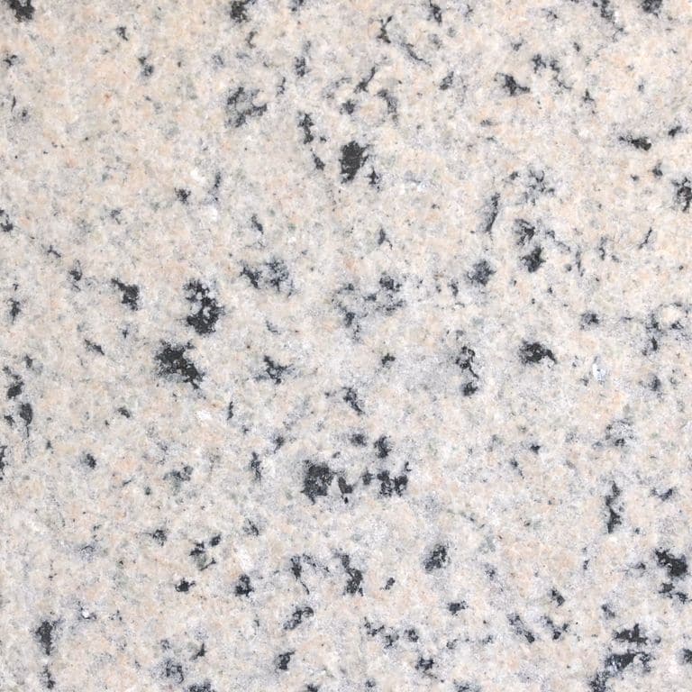 Feature image for Granite - Milford Pink. The surface finish shown is flamed. Dominant colors shown are gray, pink and white; with beige, black and cream secondaries. The color mix creates a cool feeling. Coarse speckled color pattern. Contains some mica.