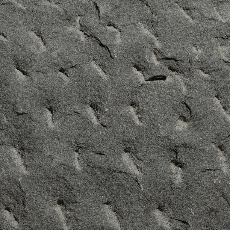 Color/Finish variation image for Sugus Black Sandstone. The surface finish shown is pineapple. Dominant colors shown are black and gray. The color mix creates a cool feeling.