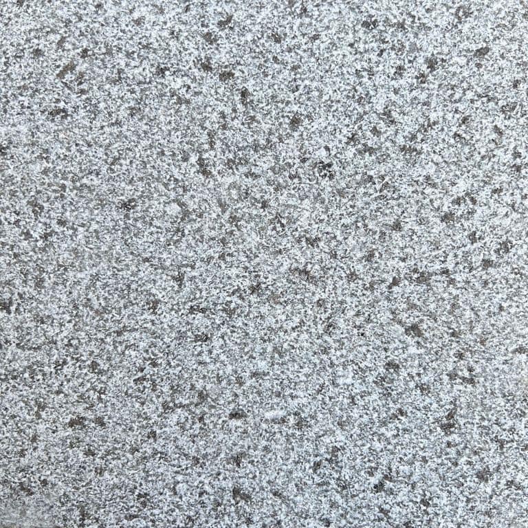 Best close-up image for Black Star Granite. The surface finish shown is flamed. Dominant colors shown are black, blue and gray. The color mix creates a cool feeling. Speckled color pattern. Contains some mica and mineral inclusions.