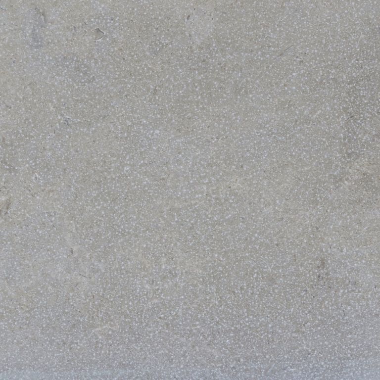 Color/Finish variation image for Estrema Light Limestone. The surface finishes shown are brushed and sand blasted. The dominant color shown is gray. The color mix creates a cool feeling. Solid and fine speckled color patterns.