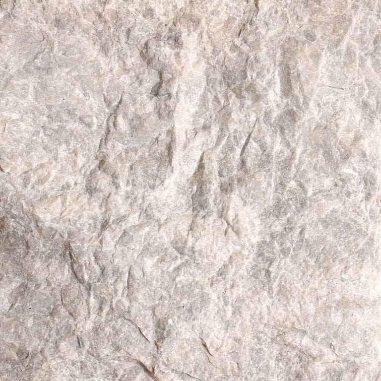 Color/Finish variation image for Dalmatian Limestone. The surface finish shown is split-face. Dominant colors shown are beige, gray and cream; with pink, purple, white and tan secondaries. The color mix creates a warm feeling. Cloudy color pattern.