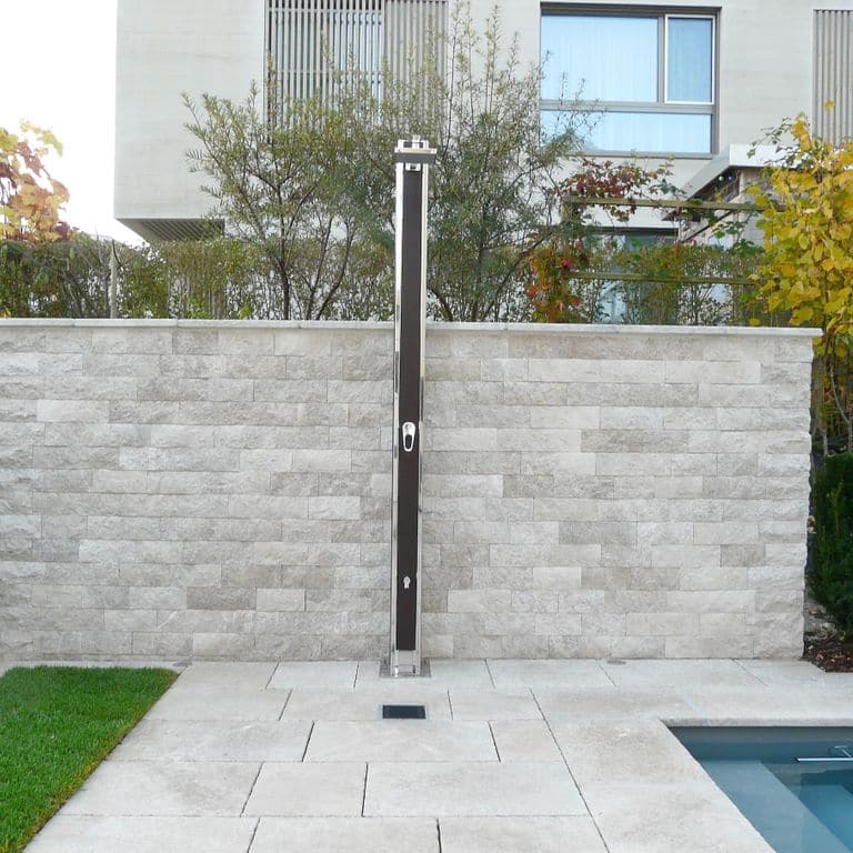 Feature image for Dalmatian Limestone. The image shows this material being used for pool coping, patio pavers, full bed veneer, thin veneer and pool deck pavers. The surface finish shown is honed. The dominant color shown is gray; with beige, blue and white secondaries. The color mix creates a warm feeling. Regular color pattern.