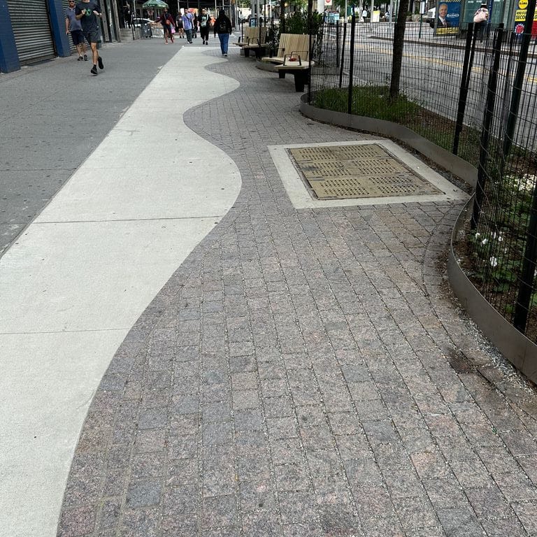 Feature image for Mahogany Granite. The image shows this material being used in a public area application. The surface finish shown is flamed. Dominant colors shown are brown and gray. The color mix creates a warm feeling.
