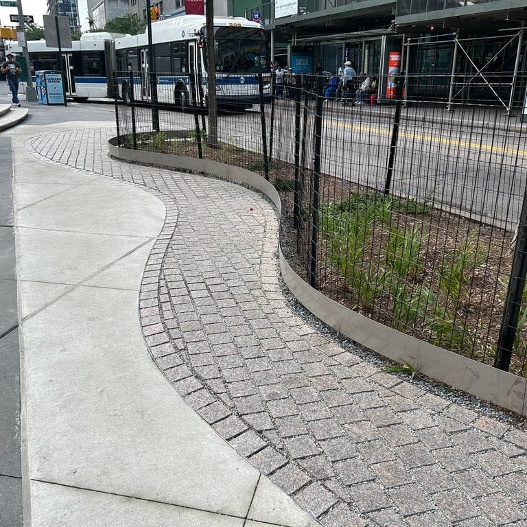 Application image for Mahogany Granite. The image shows this material being used in a public area application. The surface finish shown is flamed. Dominant colors shown are brown and gray.