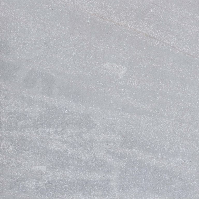 Feature image for Pacific Gray Limestone. The surface finish shown is honed. The dominant color shown is gray; with beige, blue and white secondaries. Exhibits "movement" and the color mix creates a cool feeling. Linear and cloudy color patterns.