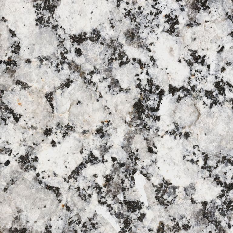 Feature image for Rockville White® Granite. The surface finish shown is flamed. The dominant color shown is gray; with beige, black, pink, purple, white and cream secondaries. The color mix creates a warm feeling. Coarse speckled color pattern. Contains some mica and mineral inclusions.