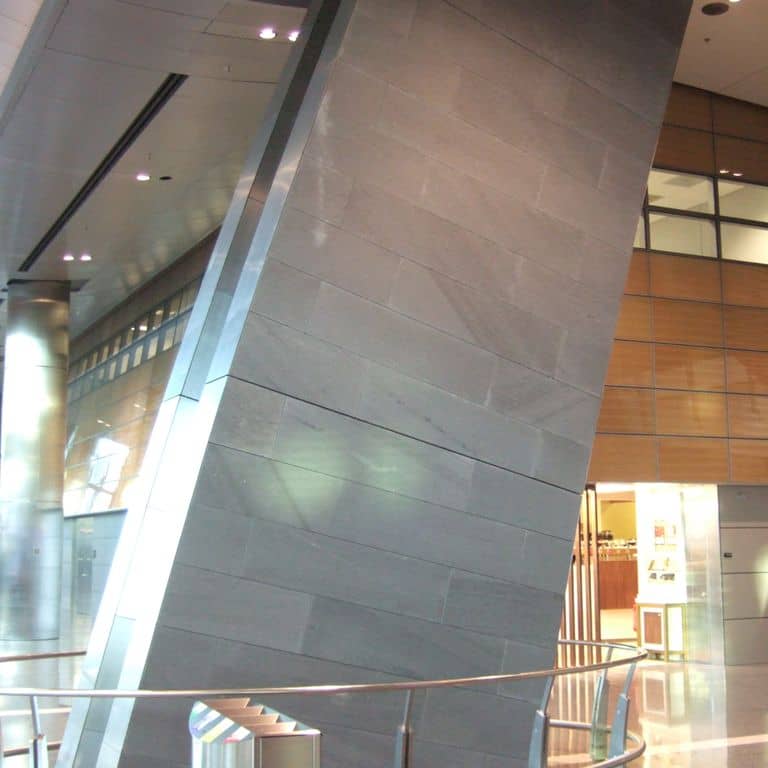 Application image for Basaltina Basalt. The image shows this material being used in a thin veneer application. The surface finish shown is honed. The dominant color shown is gray. Exhibits "movement". Solid and linear color patterns.
