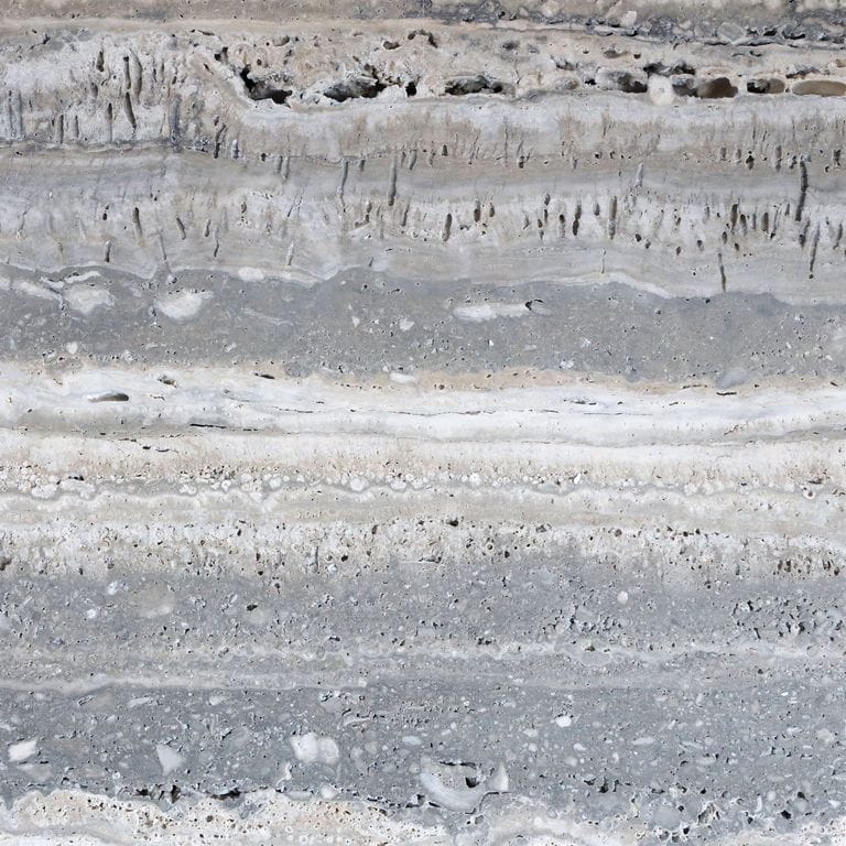 Feature image for Campione Travertine - Silver. The surface finish shown is honed. The dominant color shown is gray; with beige, blue, pink, white and tan secondaries. Exhibits "movement" and the color mix creates a cool feeling. Streaked color pattern. Contains voids.
