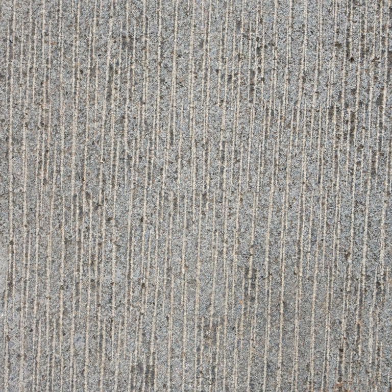 Feature image for Nordic Gray Basalt. The surface finish shown is coarse adze. The dominant color shown is gray; with beige, blue, brown, purple, white, tan and cream secondaries. The color mix creates a warm feeling. Regular color pattern.