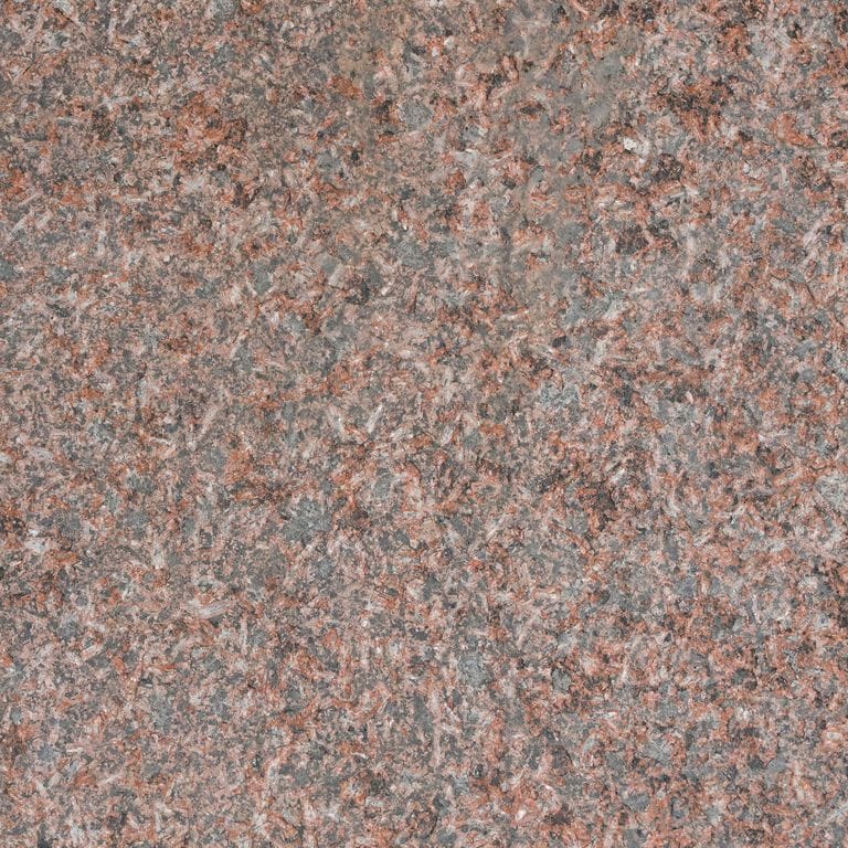 Best close-up image for Granite - Princess Red. The surface finish shown is flamed. Dominant colors shown are gray and red; with beige, green, orange/rust and purple secondaries. The color mix creates a warm feeling. Speckled color pattern. Contains some mica and mineral inclusions.