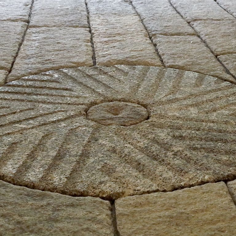 Best close-up image for Granite - Reclaimed Antique Farm and Mill Stones. The image shows this material being used in a path pavers application. The surface finish shown is . Dominant colors shown are brown and gray; with orange/rust and tan secondaries. The color mix creates a warm feeling. Regular and fine speckled color patterns.