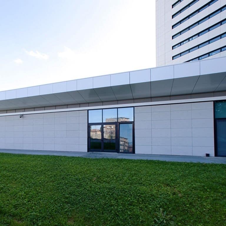 Application image for Veneto Olivo Limestone - Veneer. The image shows this product being used in a full bed veneer application. The surface finish shown is sand blasted. Dominant colors shown are gray and tan.