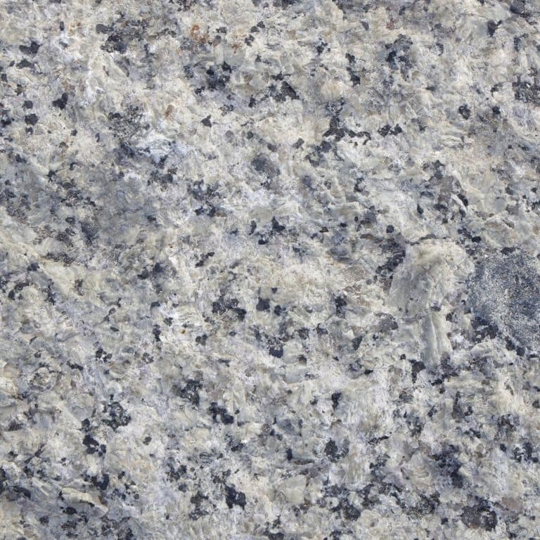 Color/Finish variation image for Reclaimed First Generation Curbstone - Split Bottom Riser Steps. The dominant color shown is gray; with beige, blue and white secondaries. The color mix creates a cool feeling. Coarse speckled and blotched color patterns. Contains mineral inclusions.
