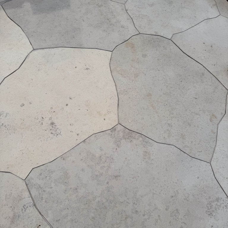 Best close-up image for Bavarian Dolomite Gray Limestone - Irregular Pavers - Waterjet Cut Edge. The image shows this product being used in a patio pavers application. The dominant color shown is gray. The color mix creates a warm feeling.