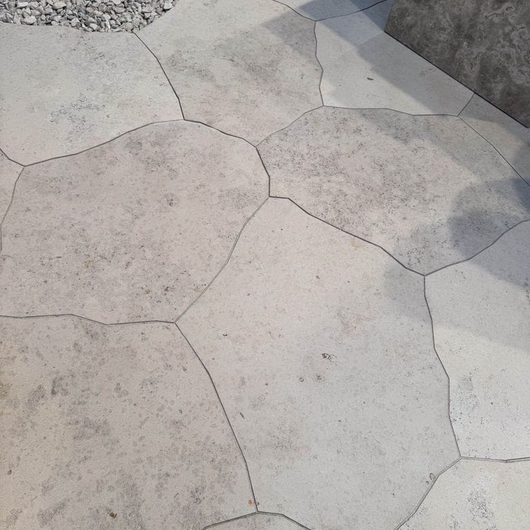 Application image for Bavarian Dolomite Gray Limestone - Irregular Pavers - Waterjet Cut Edge. The image shows this product being used in a patio pavers application. The dominant color shown is gray. The color mix creates a warm feeling.