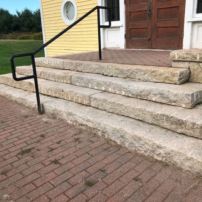 Feature image for Cape Neddick Clear Granite - Split Steps. The image shows this product being used in a monolithic steps application. Dominant colors shown are beige, gray and tan; with brown, white and cream secondaries. Speckled color pattern.