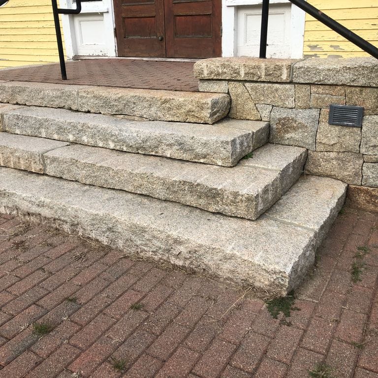 Application image for Cape Neddick Clear Granite - Split Steps. The image shows this product being used in a monolithic steps application. This is a building and landscape stone for indoor and outdoor commercial and residential applications. Suitable for general use, freeze-thaw conditions, low heat absorption surfaces, high traffic areas, low slipperiness surfaces and high heel compatibilty situations. Moderate to higher on the price spectrum.