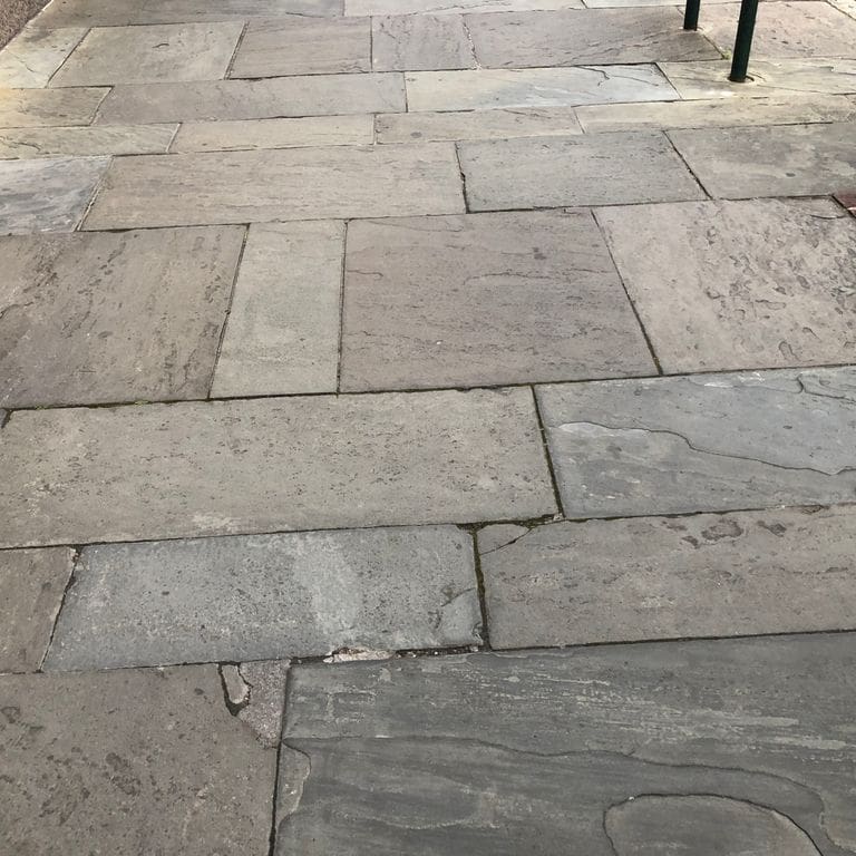 Feature image for Reclaimed Bluestone Hand Cut Pavers. The image shows this product being used in a path pavers application. The surface finish shown is natural cleft. The dominant color shown is gray. The color mix creates a warm feeling.