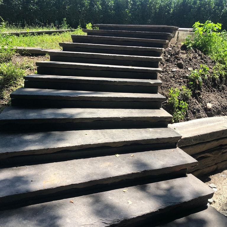 Application image for Reclaimed Bluestone Hand Cut Pavers. The image shows this product being used in a treads application. The surface finish shown is natural cleft. The dominant color shown is gray. The color mix creates a warm feeling.