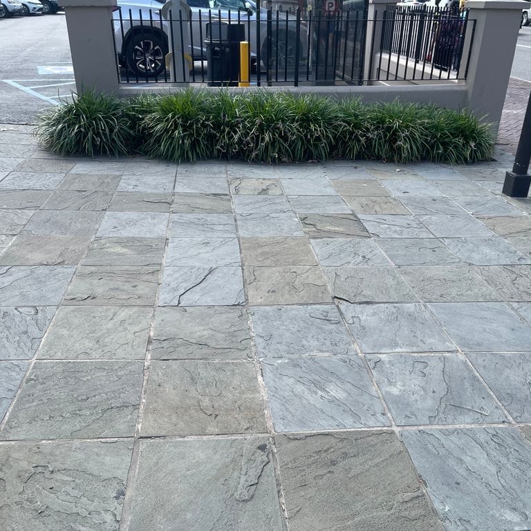 Application image for Reclaimed Bluestone Hand Cut Pavers. The image shows this product being used for patio pavers and public area. The surface finish shown is natural cleft. Dominant colors shown are blue and gray. The color mix creates a cool feeling.