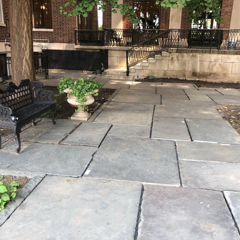 Application image for Reclaimed Bluestone Hand Cut Pavers. The image shows this product being used in a patio pavers application. The surface finish shown is natural cleft. The dominant color shown is gray.