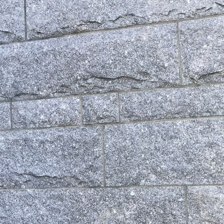 Application image for Deer Isle Granite - Cut to Size Veneer. The image shows this product being used in a full bed veneer application. The surface finish shown is split-face. The dominant color shown is gray. The color mix creates a cool feeling.