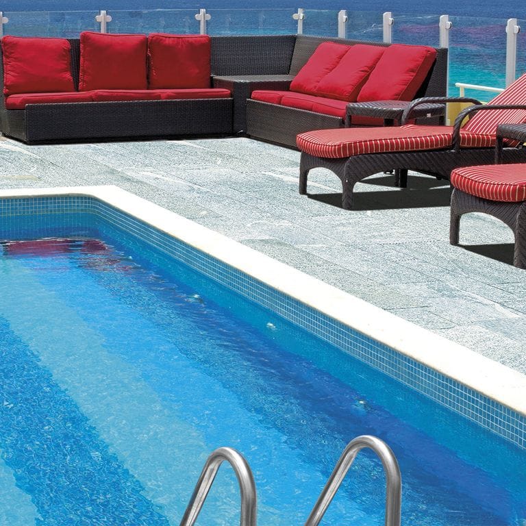 Feature image for Pietra Italia Gray Gneiss - Pool Deck. The image shows this product being used in a pool deck pavers application. The dominant color shown is gray. The color mix creates a cool feeling.