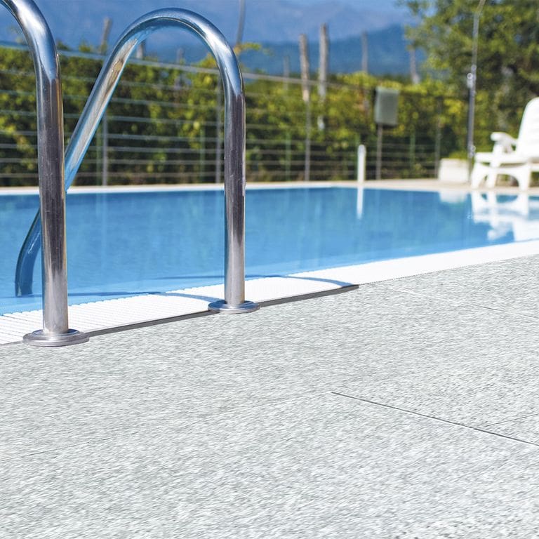 Application image for Pietra Italia Gray Gneiss - Pool Deck. The image shows this product being used in a pool deck pavers application. The dominant color shown is gray. The color mix creates a cool feeling.