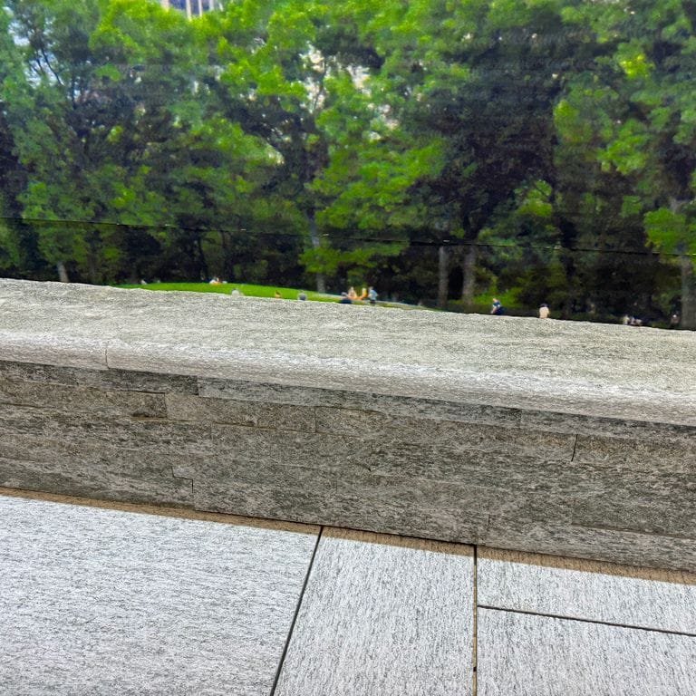 Application image for Pietra Italia Gneiss - Capstones. The image shows this product being used in a wallstone cap application. Dominant colors shown are gray and tan. The color mix creates a warm feeling.