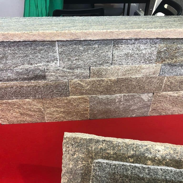 Application image for Pietra Italia Gneiss - Capstones. The image shows this product being used in a wallstone cap application. Dominant colors shown are gray and tan. The color mix creates a warm feeling.