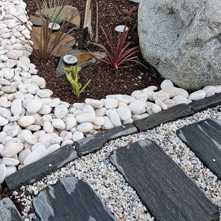 Application image for Black Schist - Tumbled Pavers. The image shows this product being used in a path pavers application. The surface finish shown is natural cleft. The dominant color shown is black. The color mix creates a cool feeling.
