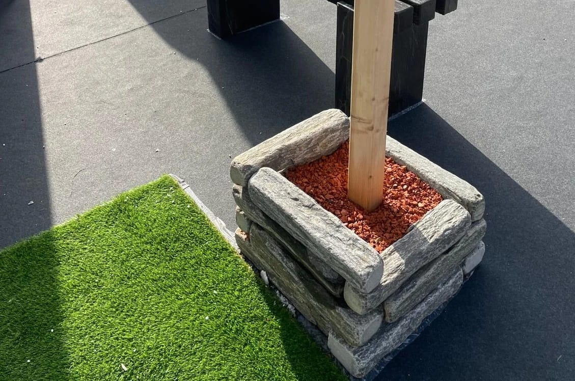 Application image for Black Schist - Tumbled Edging. The image shows this product being used in a landscape curbing &amp; edging application. The surface finish shown is natural cleft. Dominant colors shown are black and gray. The color mix creates a cool feeling.