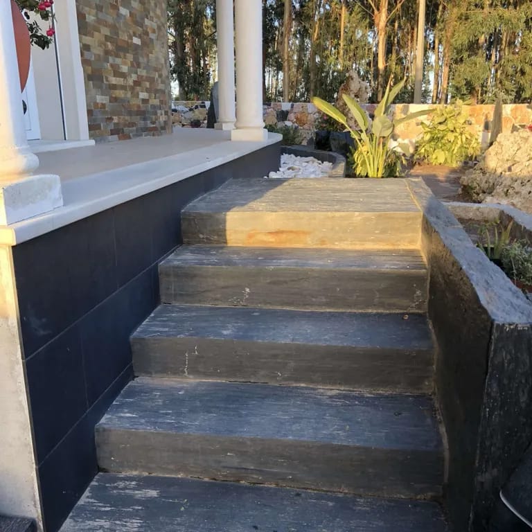 Application image for Black Schist - Steps, Treads &amp; Landings. The image shows this product being used in a monolithic steps application. The surface finish shown is natural cleft. Dominant colors shown are black, gray and orange/rust.